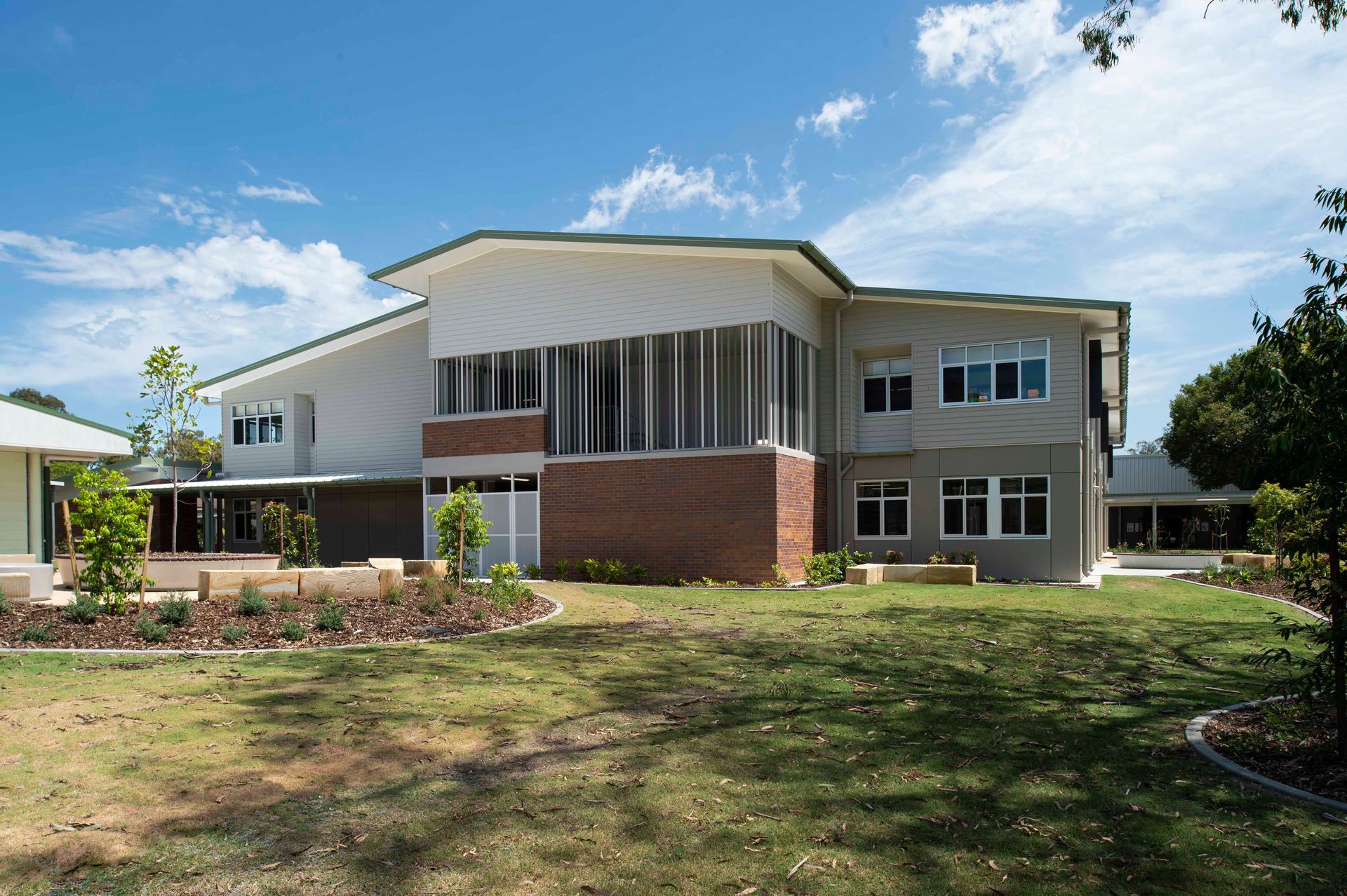 A classroom with tables and chairs and a flat screen tv on the wall.