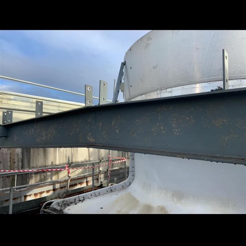 A close up of a metal structure with a white object in the background