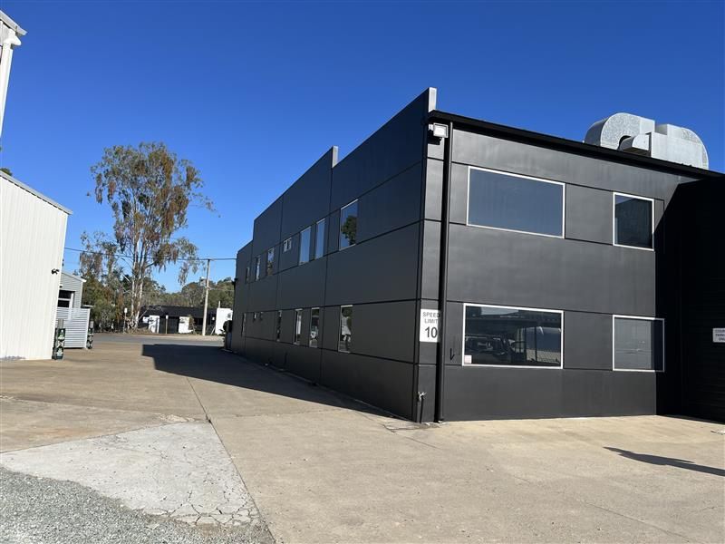 A large black building with a lot of windows and a blue sky in the background.