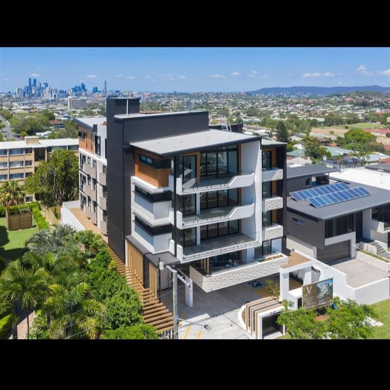 An aerial view of a large apartment building with a city in the background.