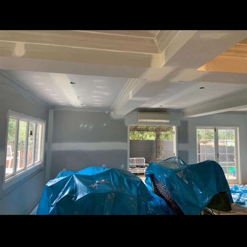 A room with a lot of windows and a blue tarp on the floor.