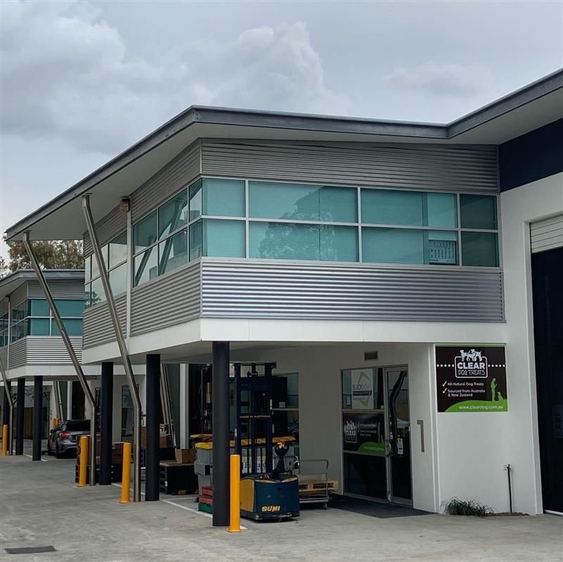 A large building with a lot of windows and a forklift in front of it