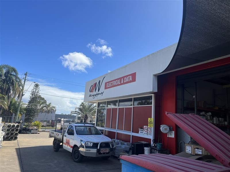 A white truck is parked in front of a building.