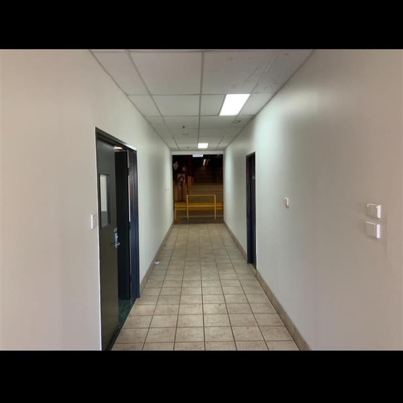 A long hallway with tile floors and white walls