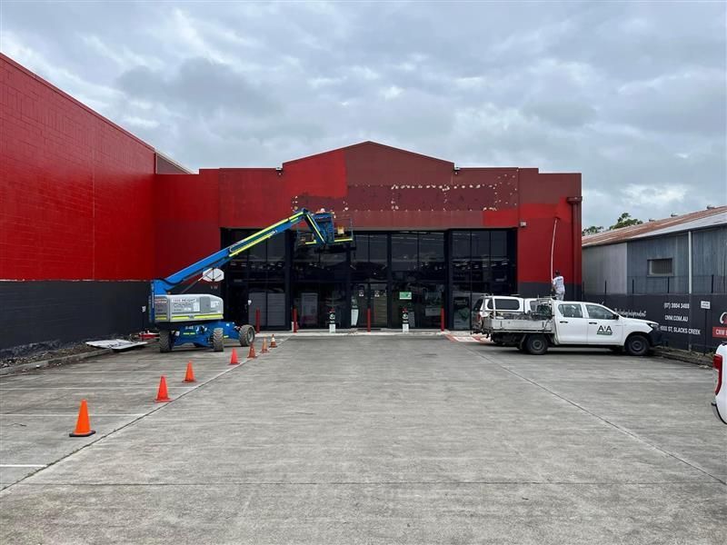 A large red building with a lot of cars parked in front of it.