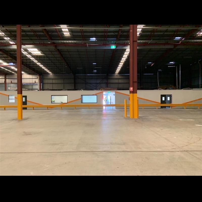 A large empty warehouse with a lot of windows and doors.