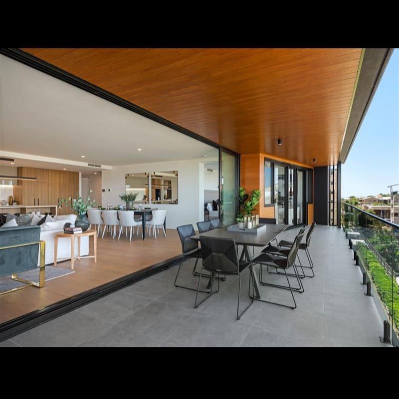 A large balcony with a dining table and chairs
