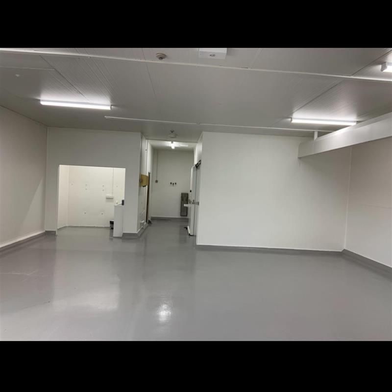 A large empty room with a gray floor and white walls.