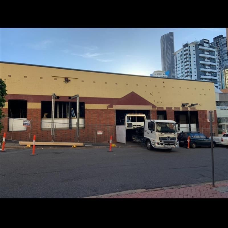 Two trucks are parked in front of a building