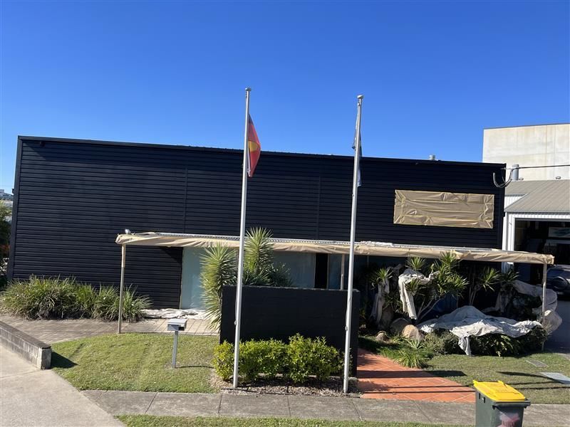 A black building with two flags in front of it.