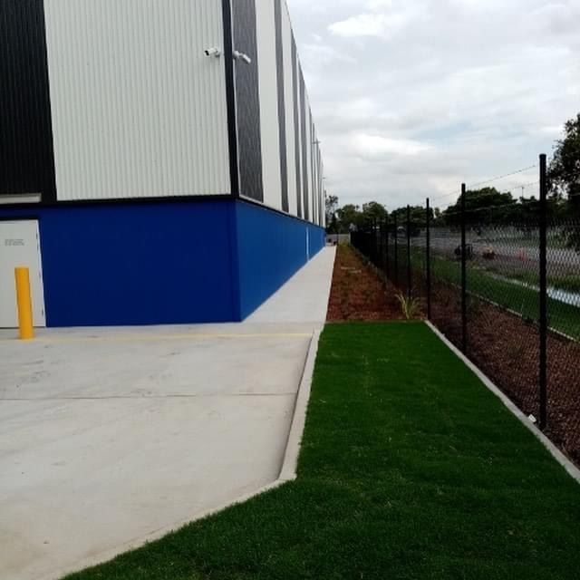 A blue and white building with a fence in front of it