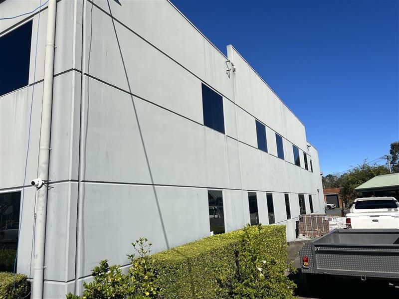 A white truck is parked in front of a large building