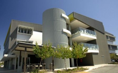 A large building with a lot of balconies and trees in front of it.