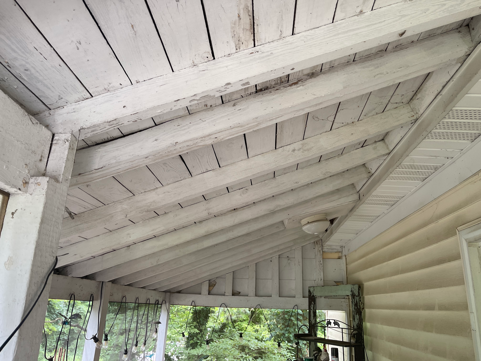 White-painted porch ceiling with exposed beams.