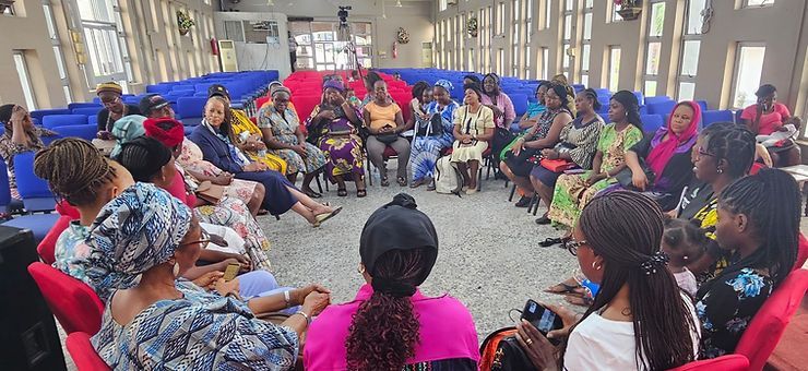 A group of women are sitting in a circle in a room.