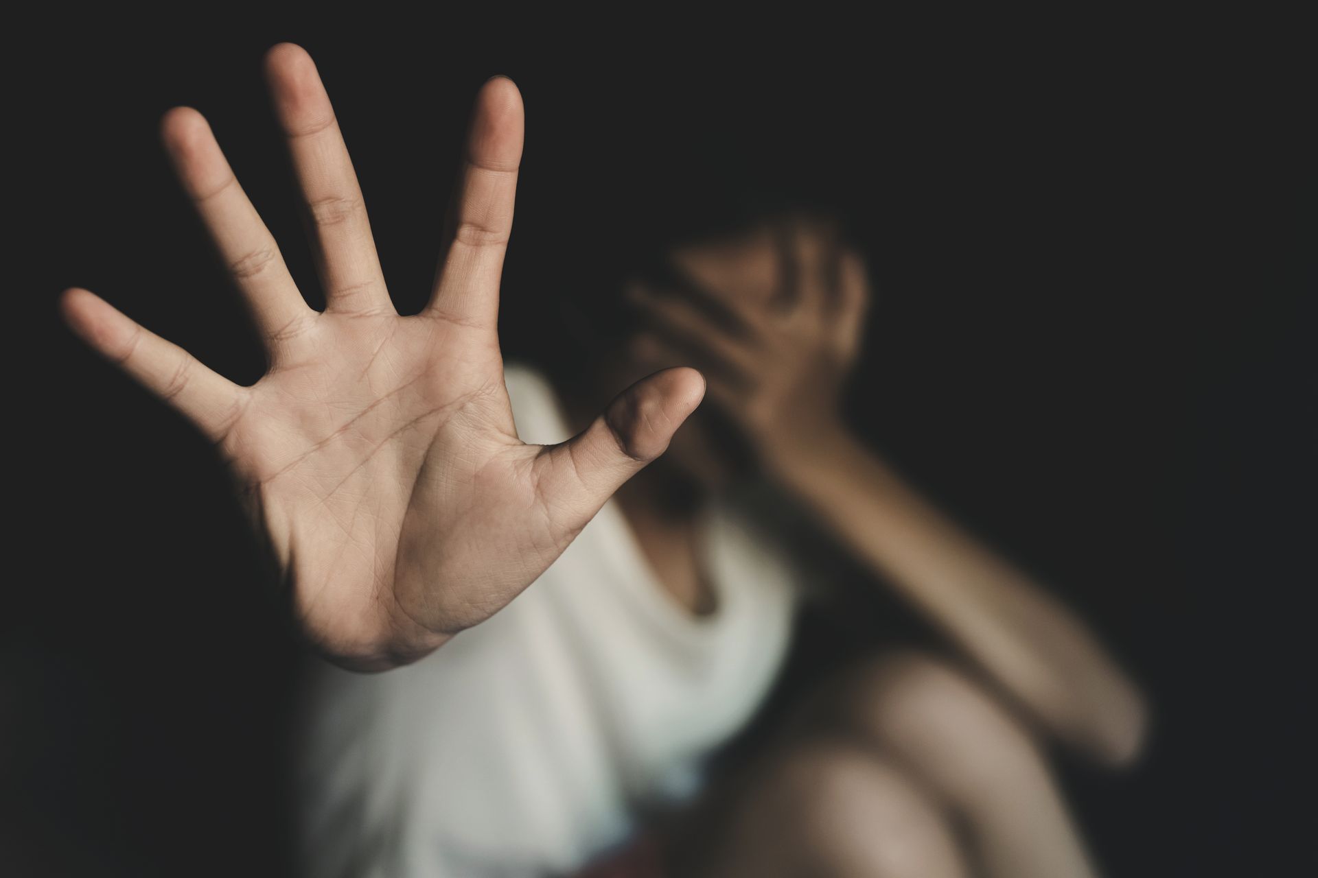 A woman is covering her face with her hand.