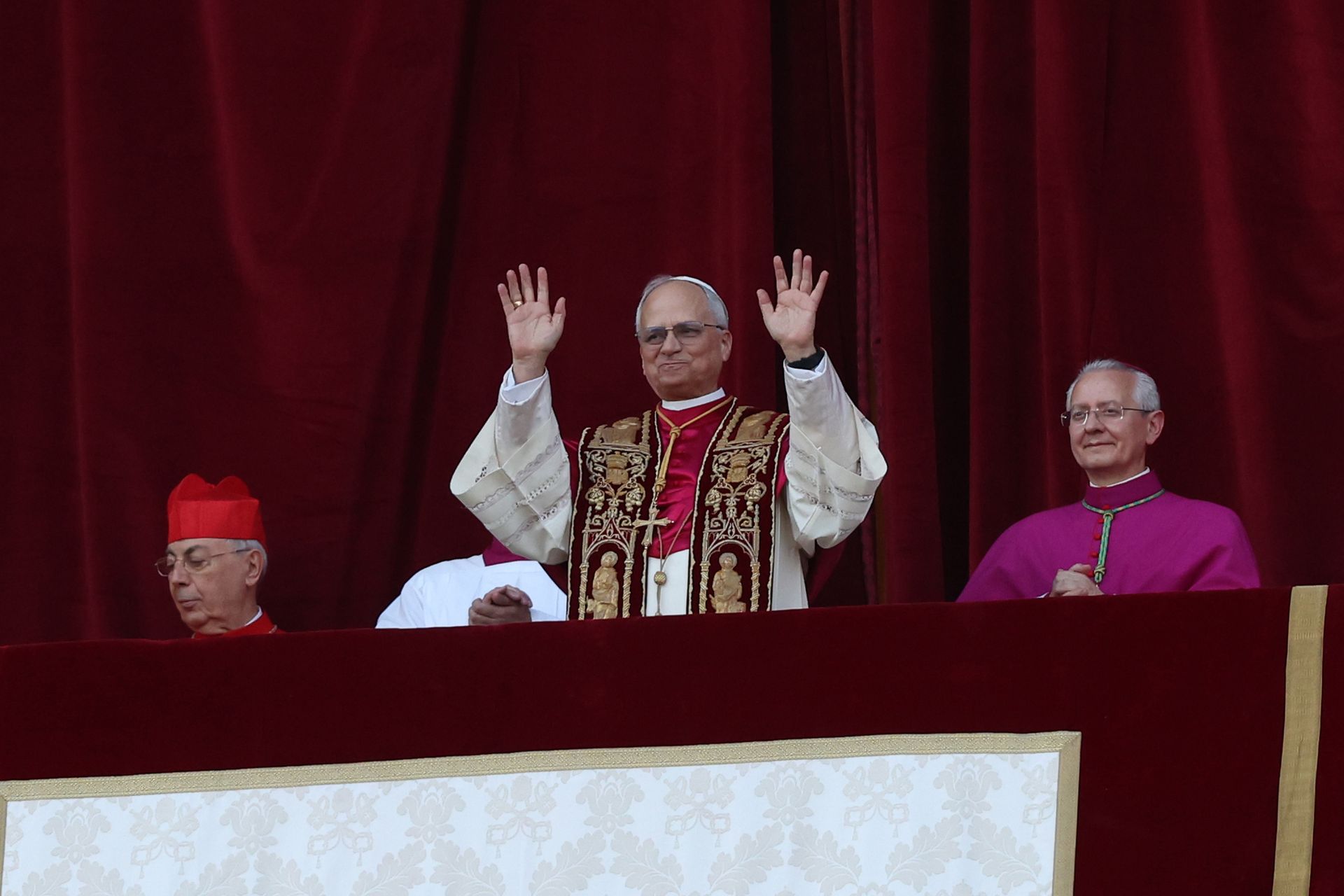 A man is standing on a balcony with his hands in the air.