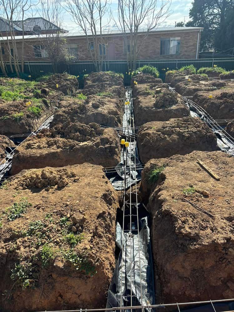 A Construction Site With a Lot of Dirt and a House in the Background — Ozi Construction Pty Ltd in Chatswood, NSW
