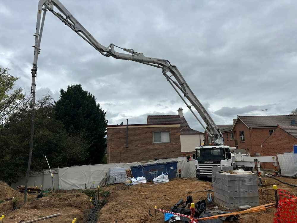 A Concrete Pump is Being Used on a Construction Site — Ozi Construction Pty Ltd in Wollongong, NSW