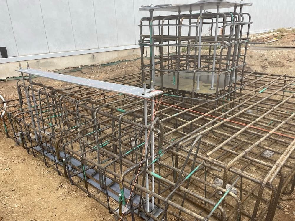 A Large Metal Cage is Sitting on Top of a Dirt Ground — Ozi Construction Pty Ltd in Balmain, NSW