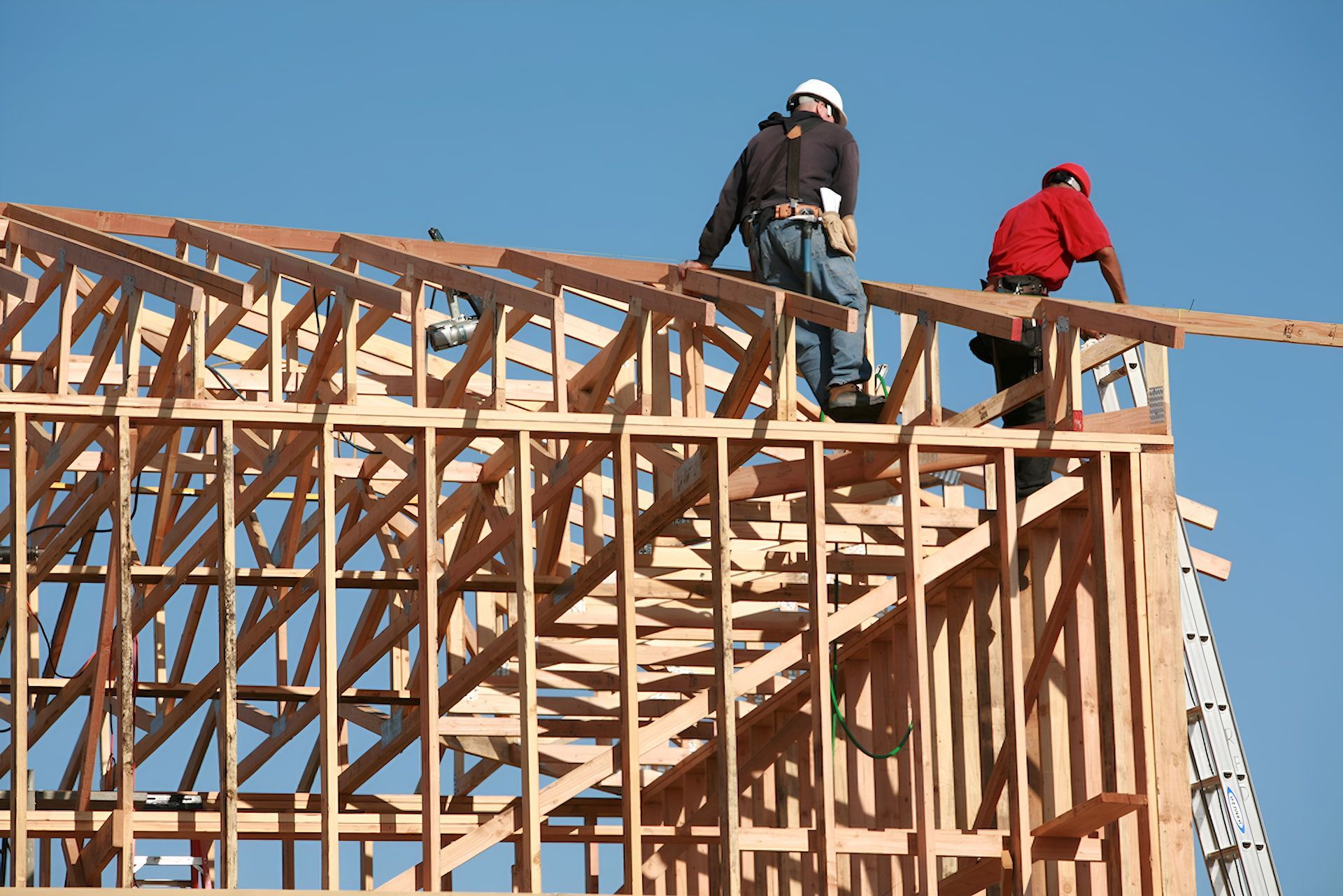 Two Men Are Working on the Roof of a Building Under Construction — Ozi Construction Pty Ltd in Canberra, NSW