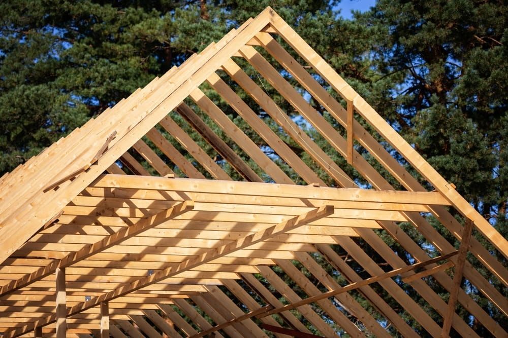 The Roof of a Building is Being Built With Wooden Beams — Ozi Construction Pty Ltd in North Sydney, NSW