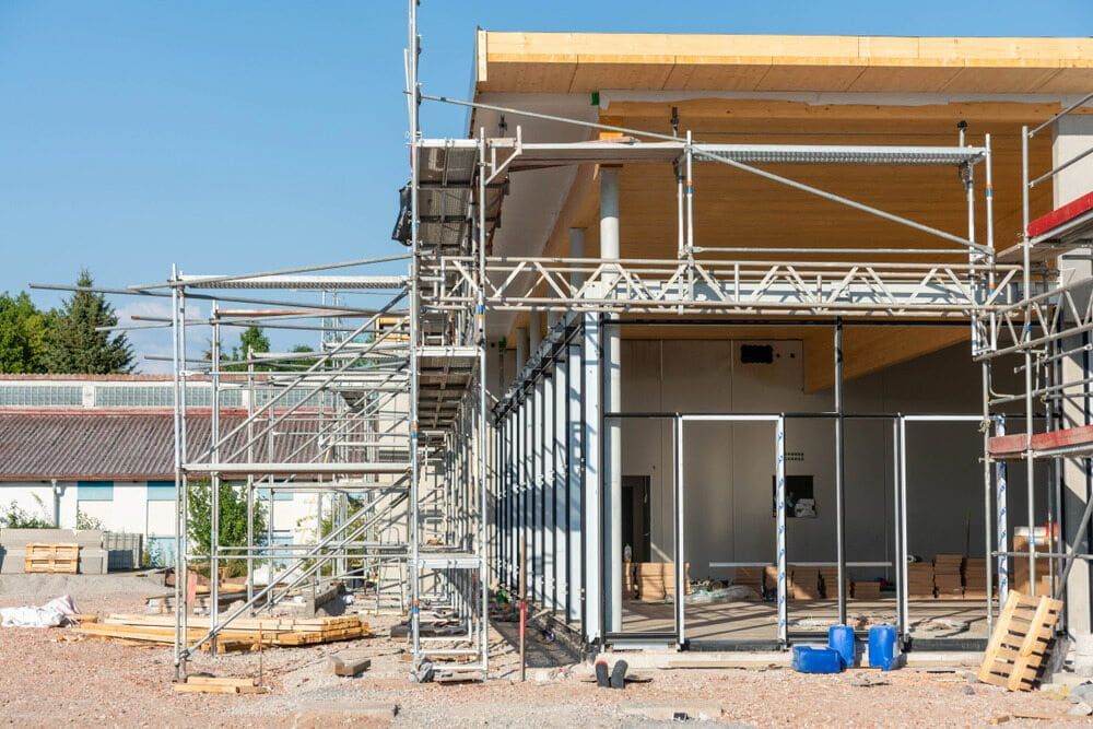 A Building is Being Built With Scaffolding Around It — Ozi Construction Pty Ltd in Mosman, NSW