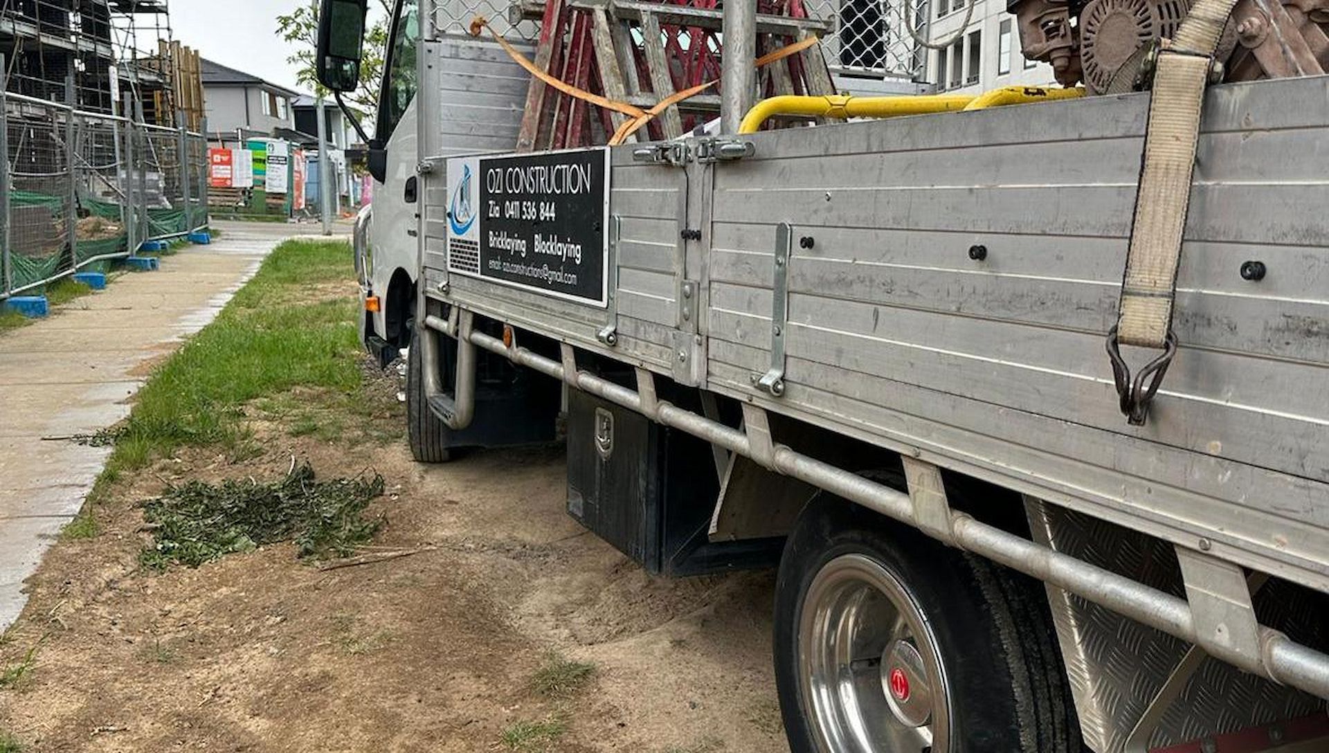 A Construction Truck Is Parked On The Grass — Ozi Construction Pty Ltd in Griffith, ACT