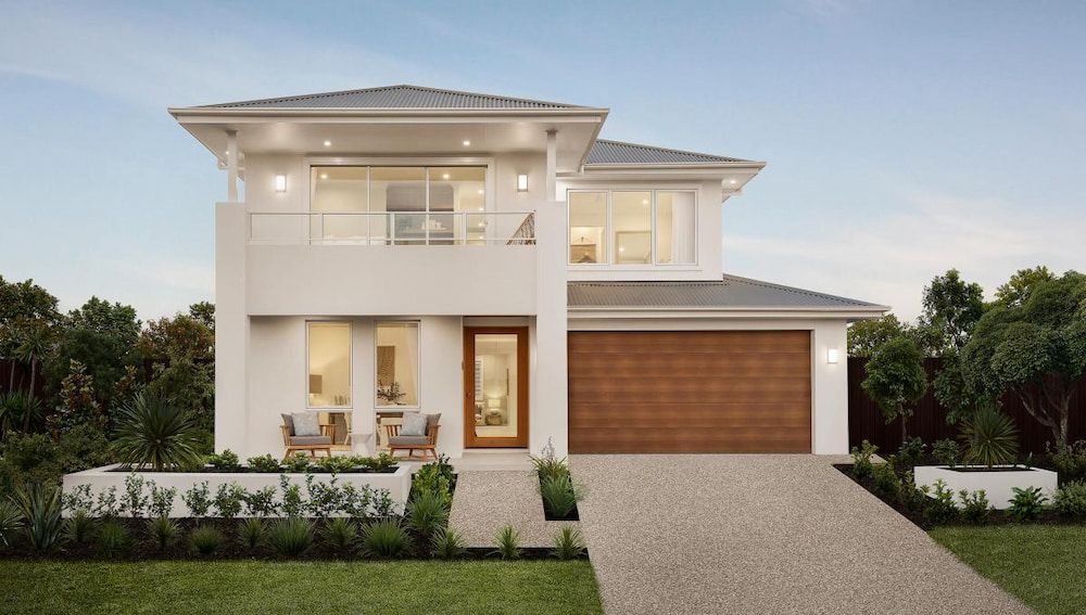A White House With a Wooden Garage Door is Sitting on Top of a Lush Green Lawn — Ozi Construction Pty Ltd in Wollongong, NSW