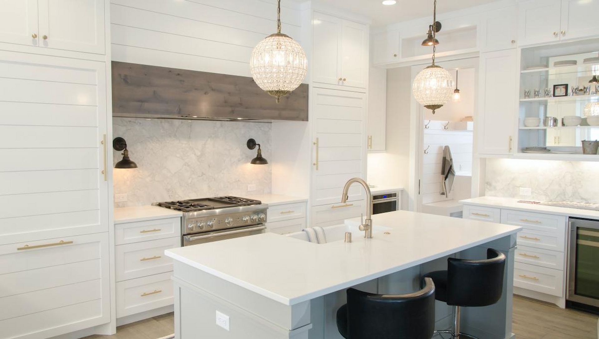 A Kitchen With White Cabinets , Stainless Steel Appliances , and a Large Island — Ozi Construction Pty Ltd in Balmain, NSW