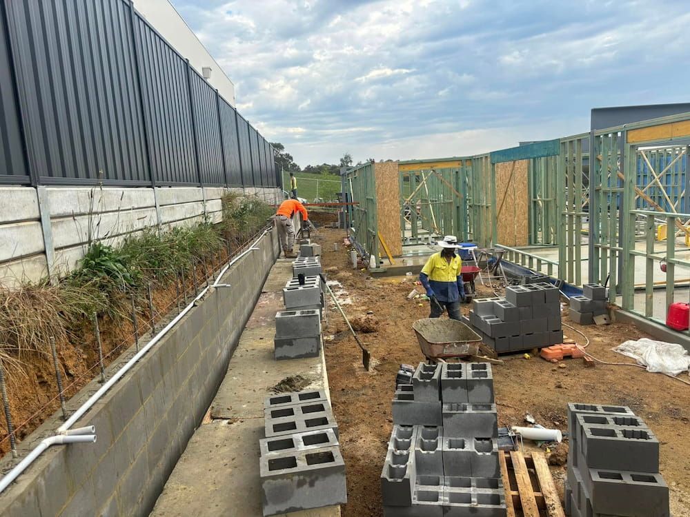 A Group of Construction Workers Are Working on a Building Under Construction — Ozi Construction Pty Ltd in Mosman, NSW