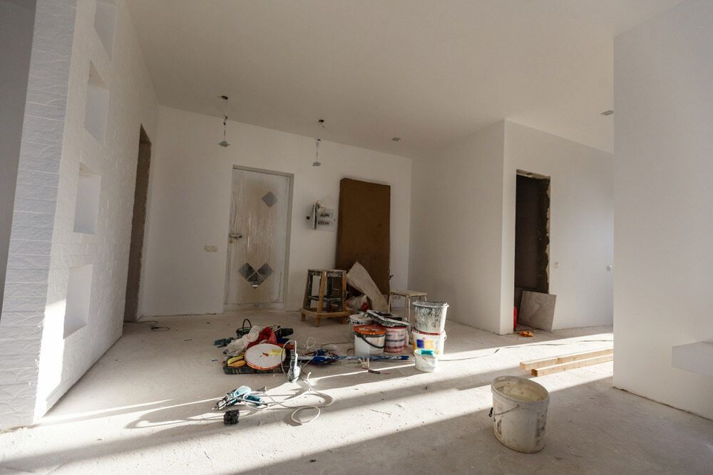 A Room With White Walls and a Bucket of Paint on the Floor — Ozi Construction Pty Ltd in Mosman, NSW