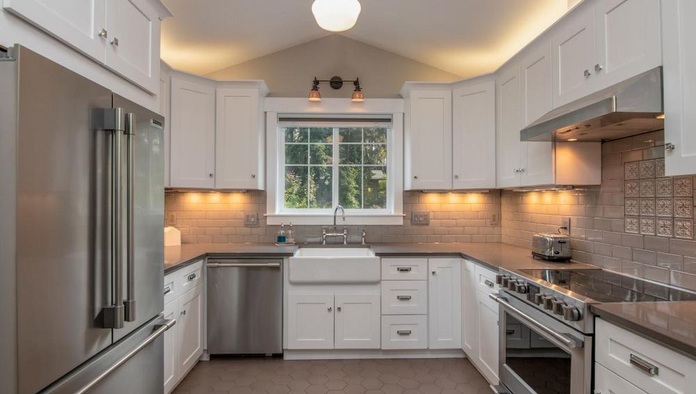 A Kitchen With White Cabinets and Stainless Steel Appliances — Ozi Construction Pty Ltd in Wollongong, NSW