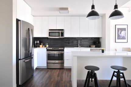 A Kitchen With White Cabinets and Stainless Steel Appliances — Ozi Construction Pty Ltd in Griffith, ACT