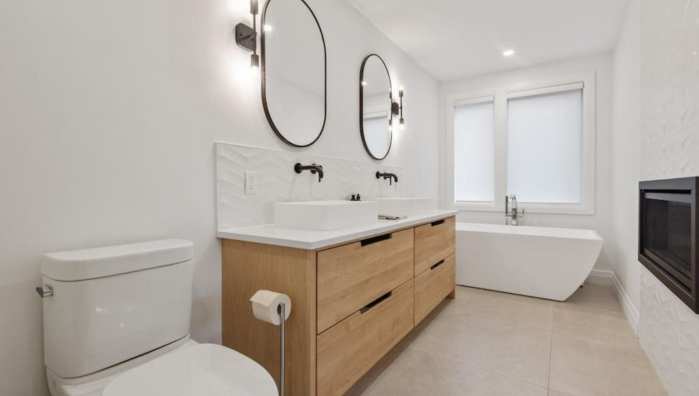 A Bathroom With Two Sinks , a Toilet , and a Bathtub — Ozi Construction Pty Ltd in Canberra, NSW