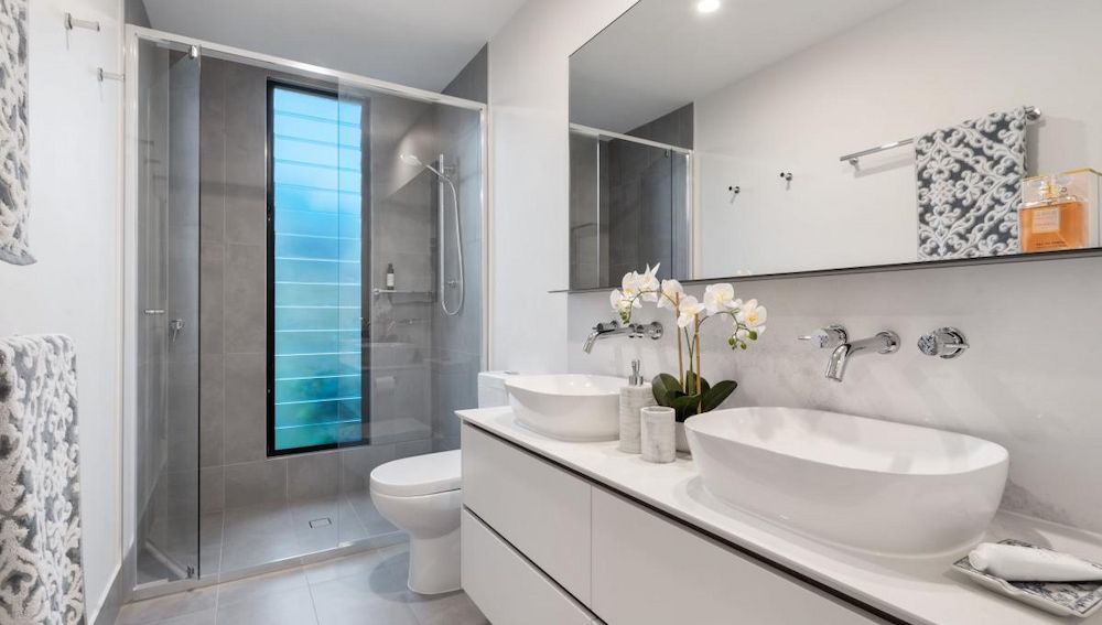 A bathroom With Two Sinks , a Toilet and a Shower — Ozi Construction Pty Ltd in Griffith, ACT