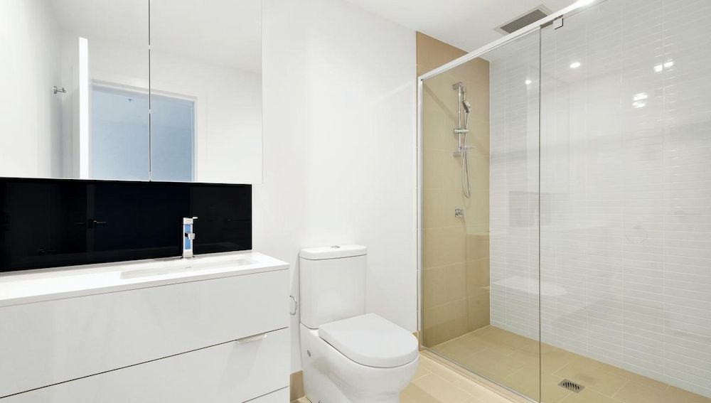A Bathroom With a Toilet, Sink and Walk in Shower — Ozi Construction Pty Ltd in Mosman, NSW
