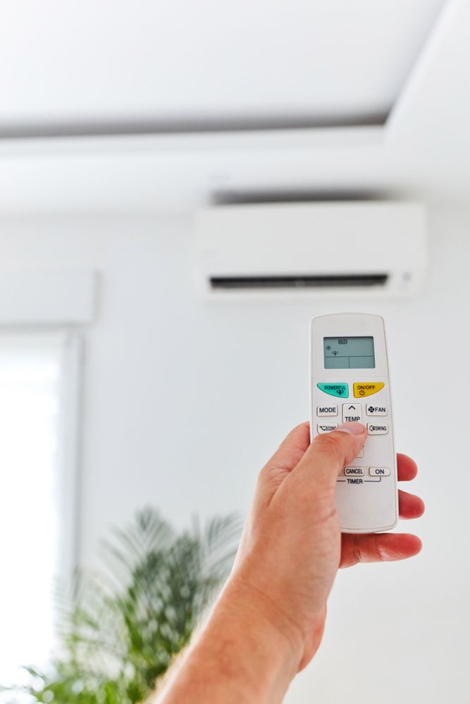 Person Holding a Air Conditioner Control Remote — Air Conditioning in Basin View NSW