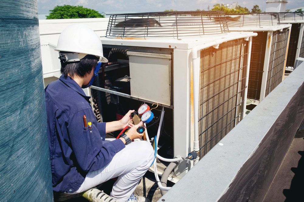 Skilled Person Checking Air Conditioner Pressure — Commercial Air Conditioning in Basin View NSW