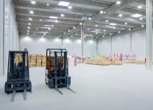Two Forklifts Are Parked in an Empty Warehouse — Lifestyle Finance Mackay in Mackay, QLD