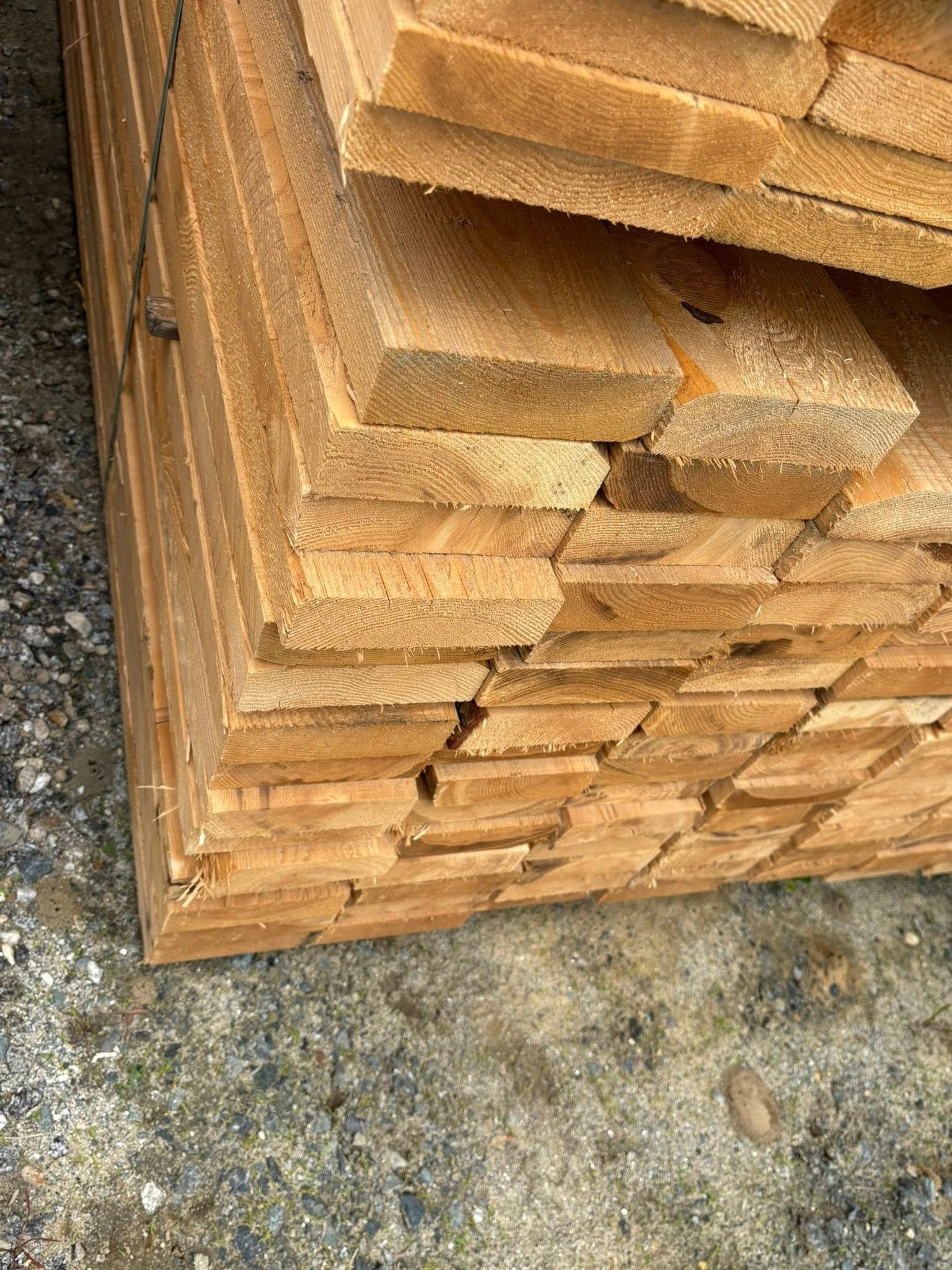 Stack of weathered, rectangular wood planks.