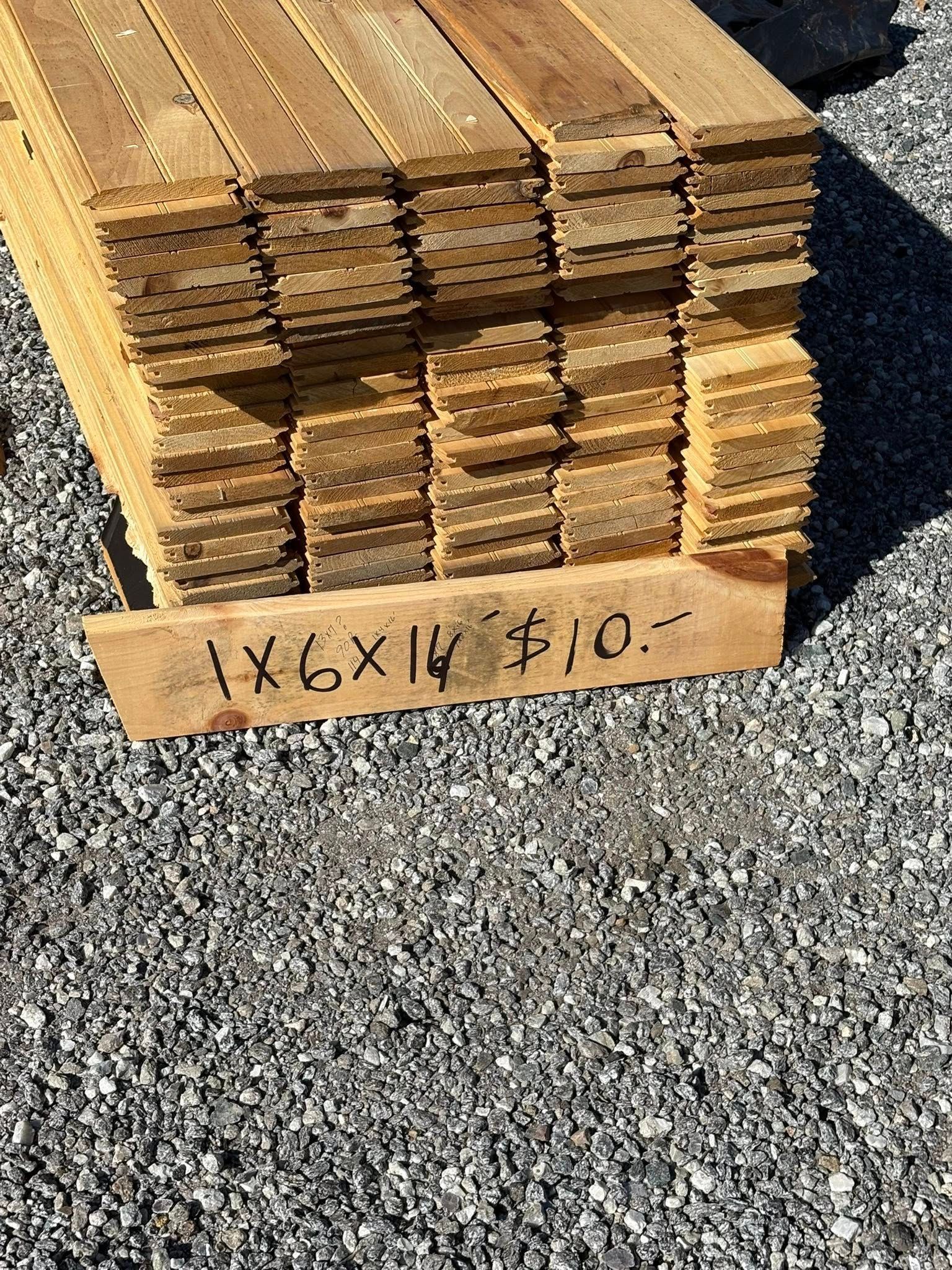 Stack of weathered wooden planks on gravel.