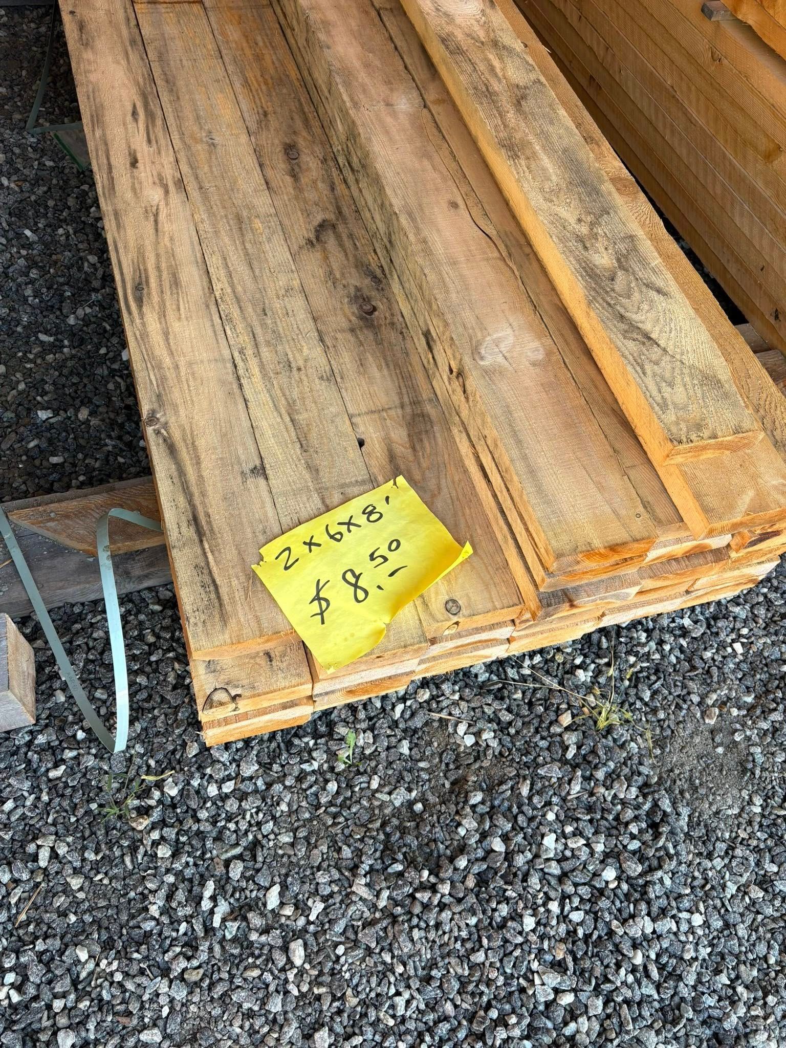 Stack of weathered wooden planks with a price tag.
