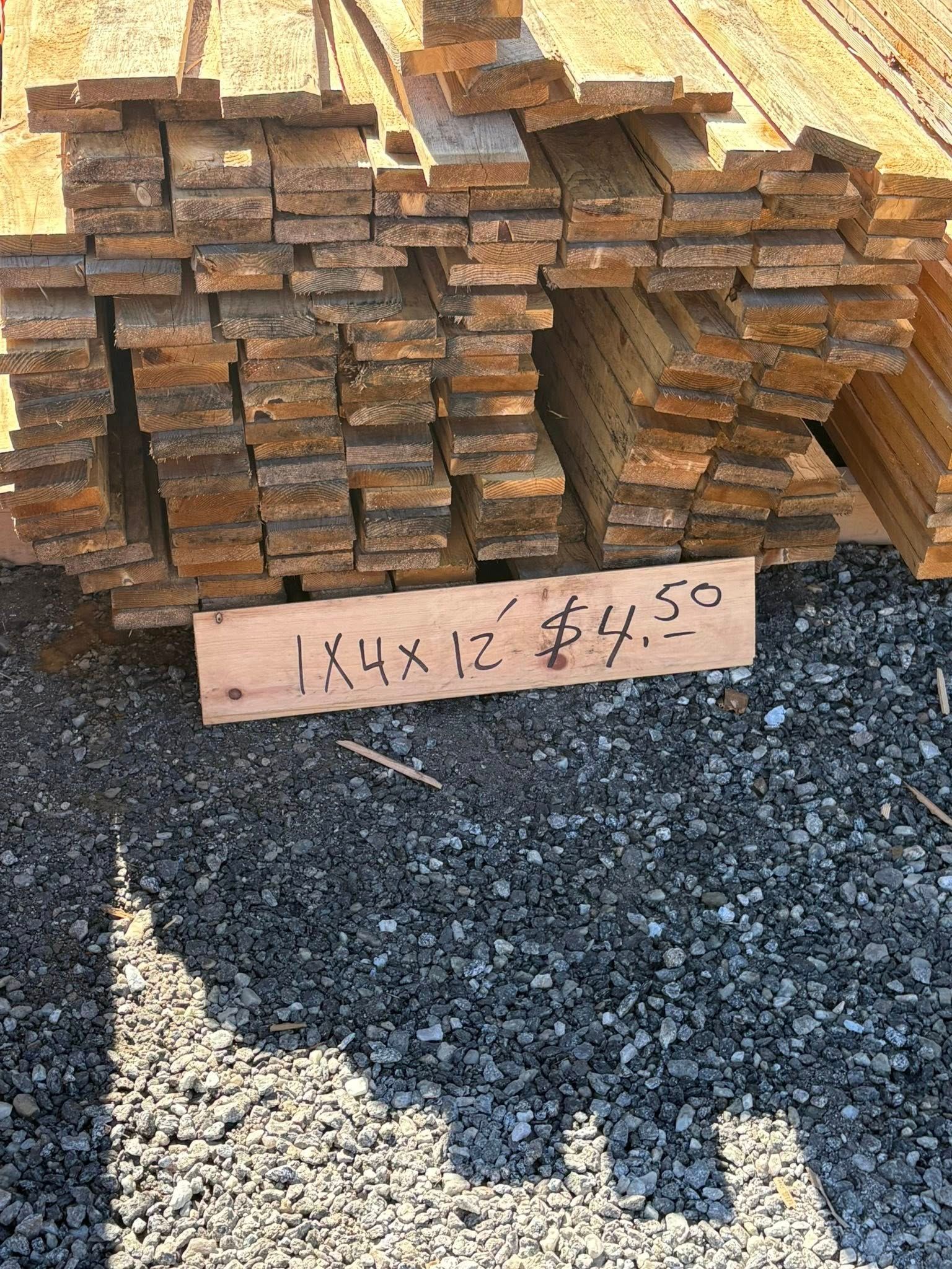 Stack of wooden boards with a price sign that reads 
