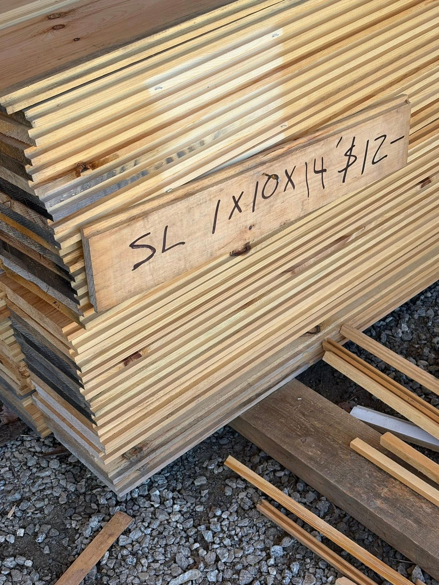 Stack of wooden planks with a handwritten price tag that reads, 