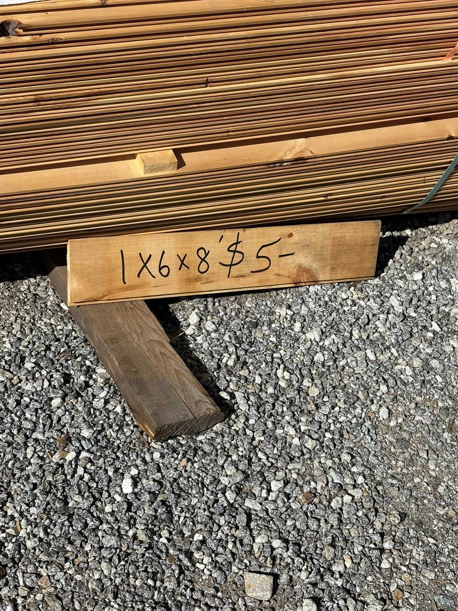 Pile of wood planks with a sign that reads 