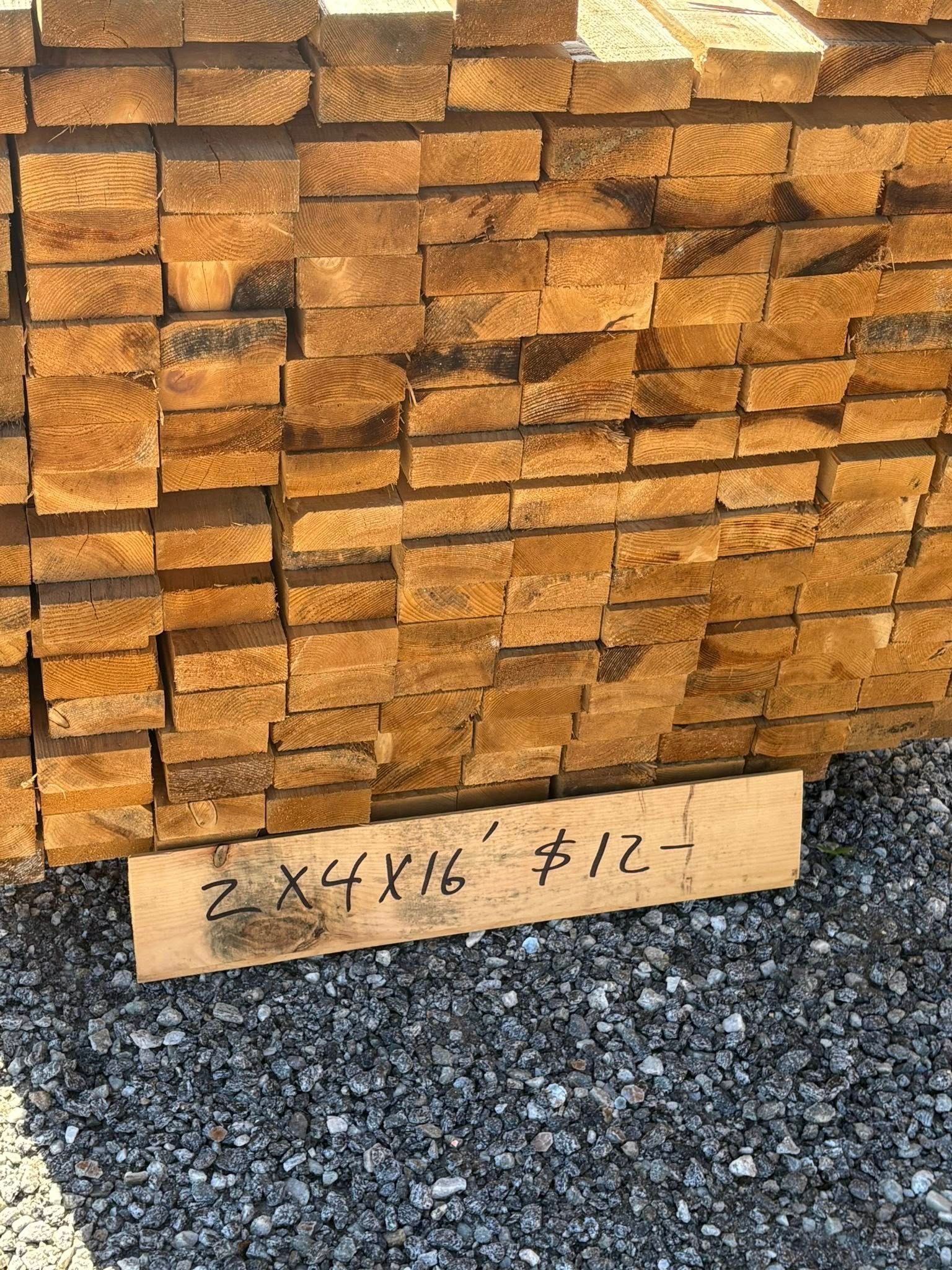 Stack of wooden boards, with a sign indicating a price.