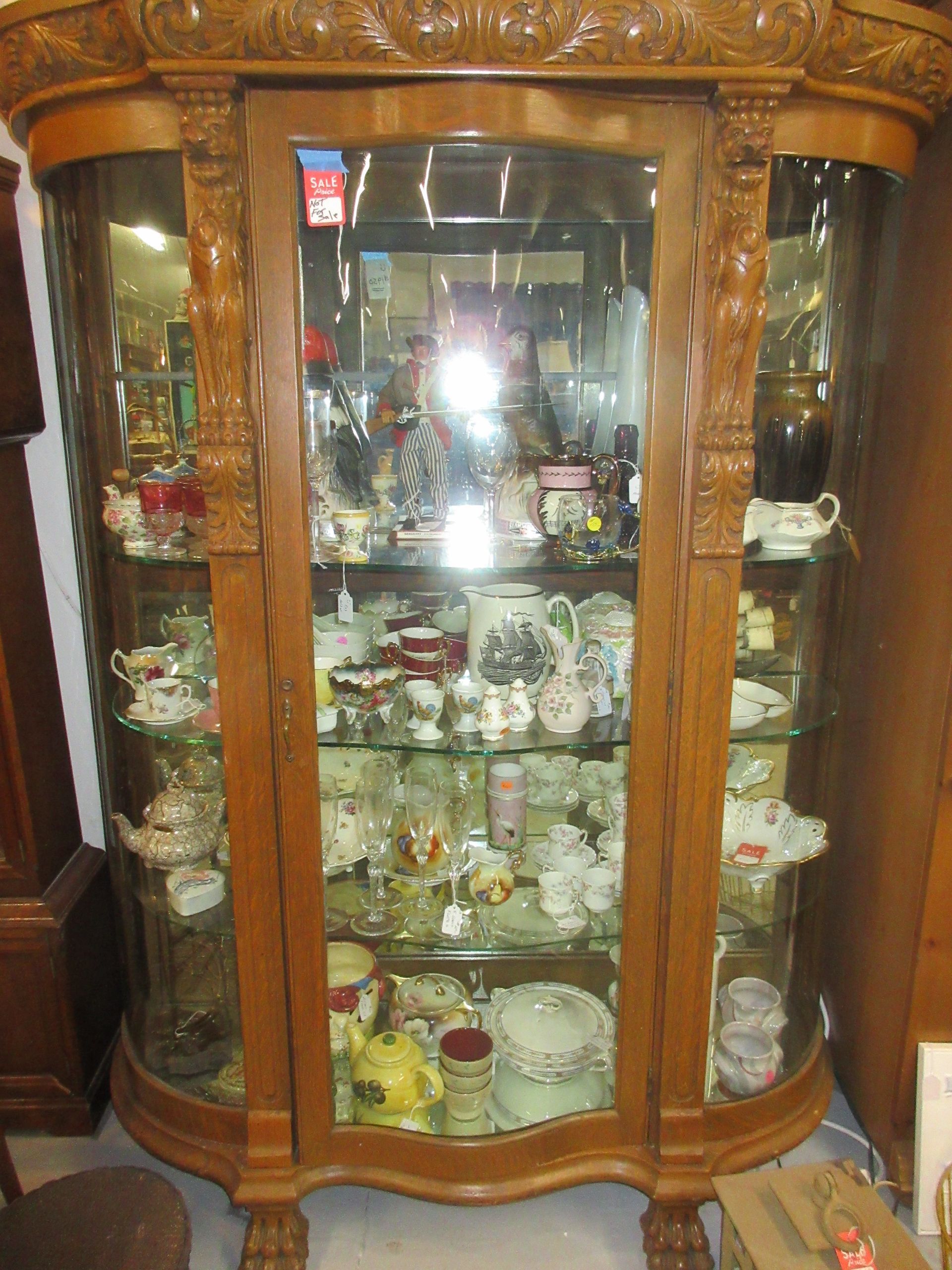 Wooden curio cabinet filled with china and glassware.