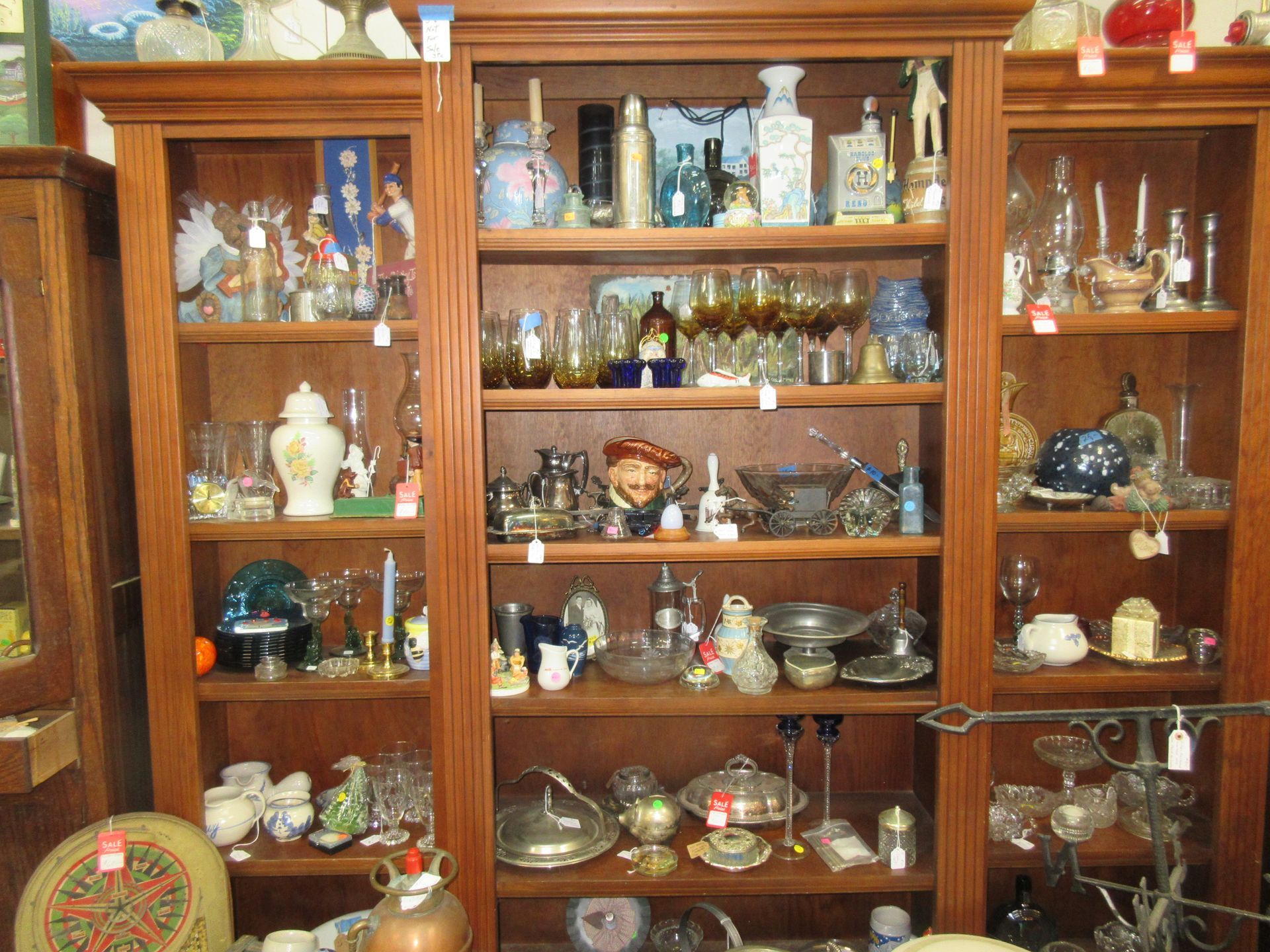 Wooden display case with shelves filled with various glassware and decor items.