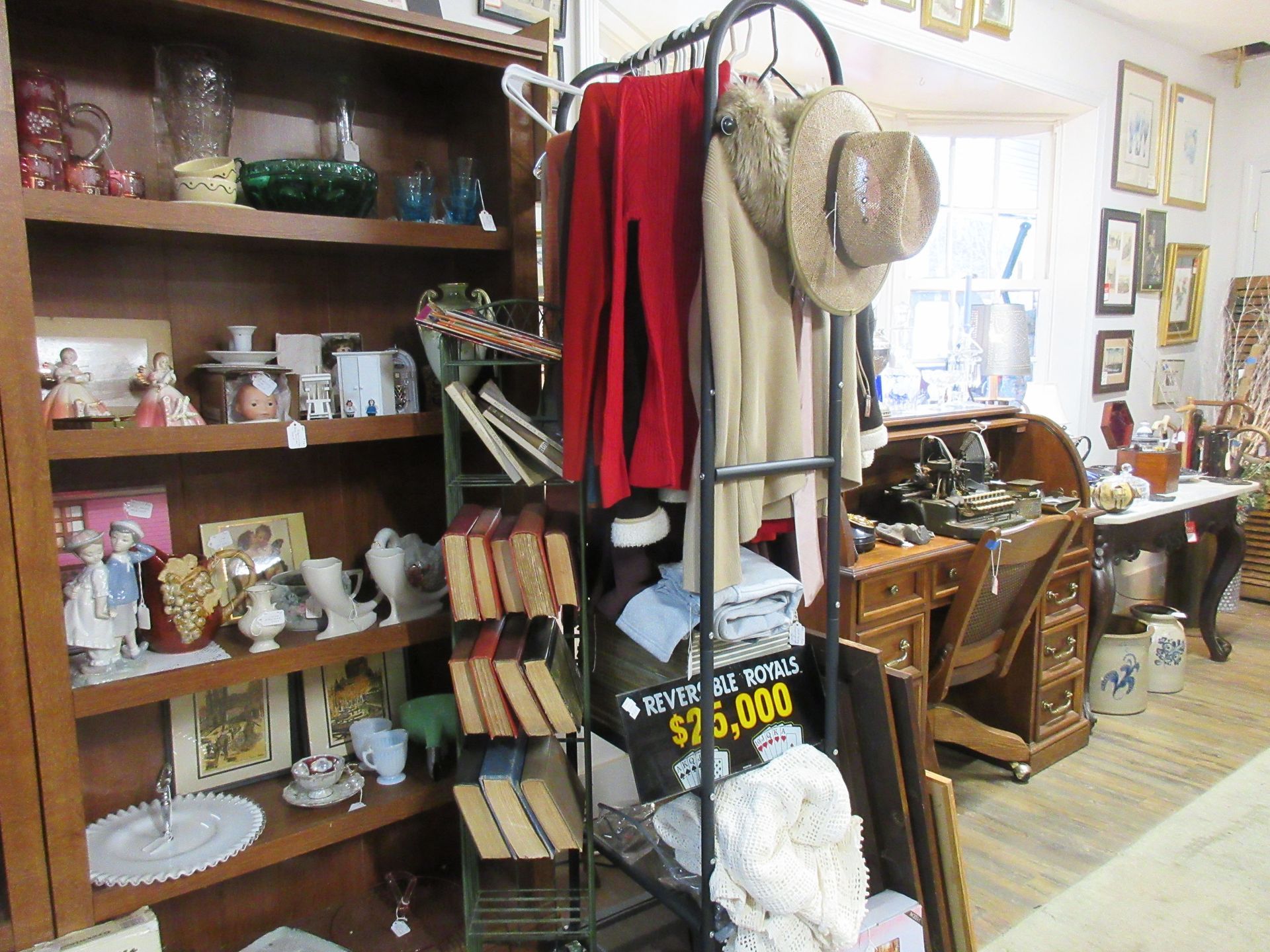 Antique store interior with shelves of items and clothing rack.